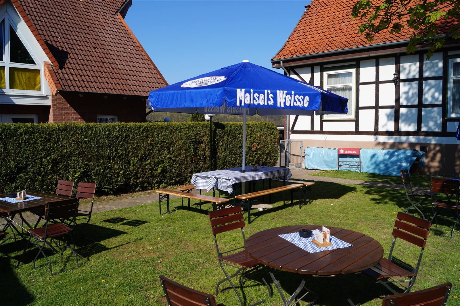 Tische und Stühle im Biergarten vor dem Fachwerkhaus