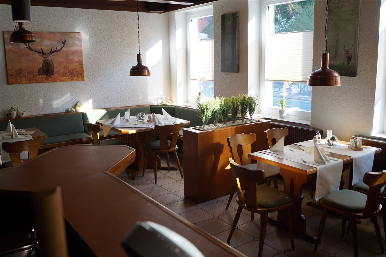 Gaststube des Restaurants Zum braunen Hirsch mit Hirschbild und gedeckten Tischen
